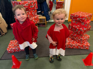 Die Weihnachtswichtel vor den Geschenketürmen